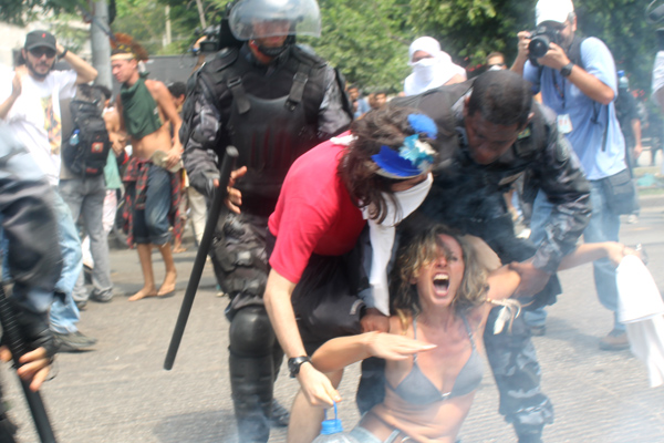 Manifestante é arrastada por policiais do Choque. Foto de Artur Romeu, usada com permissão.