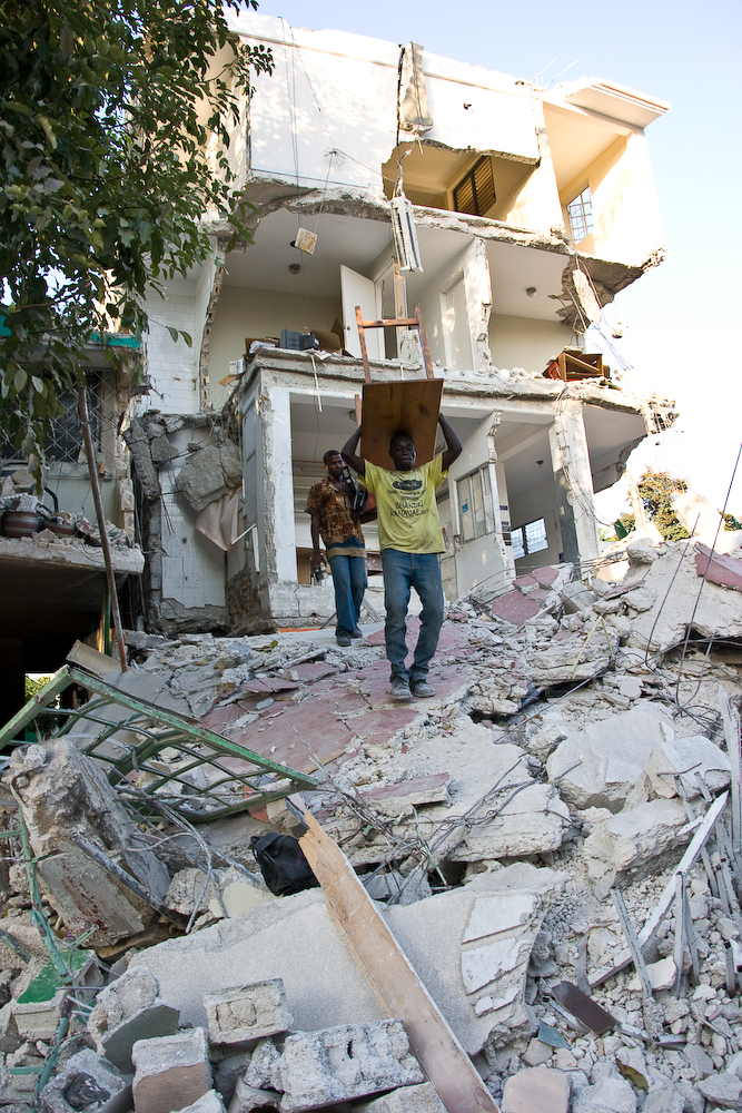 Homens tentam salvar móveis de uma casa arruinada pelo terremoto em Porto-Príncipe. Foto de Georgia Popplewell postada no Flickr sob uma licença Creative Commons.