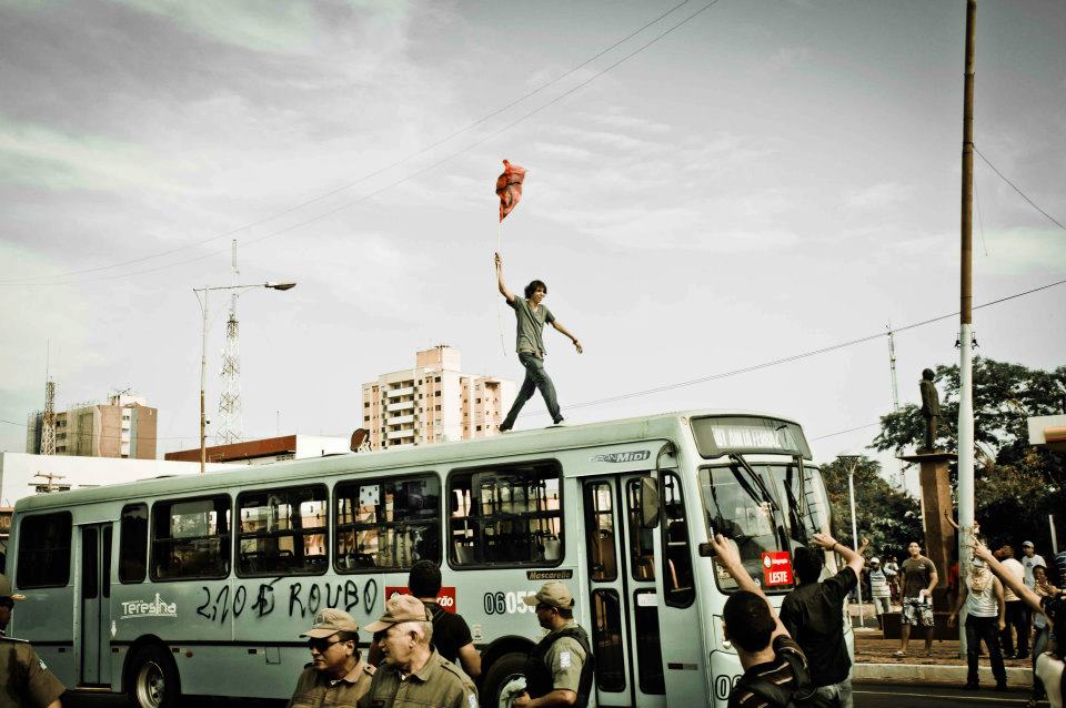 Foto dos primeiros dias de protesto, estudantes depredam ônibus em resposta à violência policial. Foto de Régis Falcão (usada com permissão).