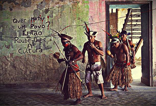 Índios em um dos edifícios do complexo. Na parede, lê-se "Quer matar um povo? Então, roube-lhes a cultura". Foto: Facebook/Aldeia Maracanã