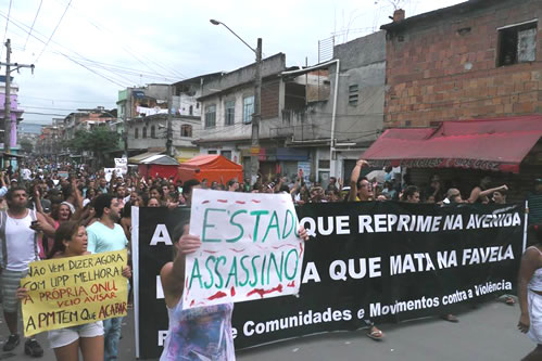 Moradores da Maré protestam no dia seguinte à chacina, em 2013. Uma faixa diz: "A polícia que reprime na avenida é a mesma que mata na favela". Foto por Equipe Marcelo Freixo (Flickr) CC BY 2.0