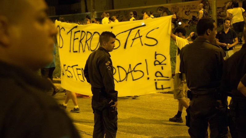Manifestantes carregam uma faixa com com os dizeres: "os terroristas vestem fardas". Foto: Gulherme Fernández.